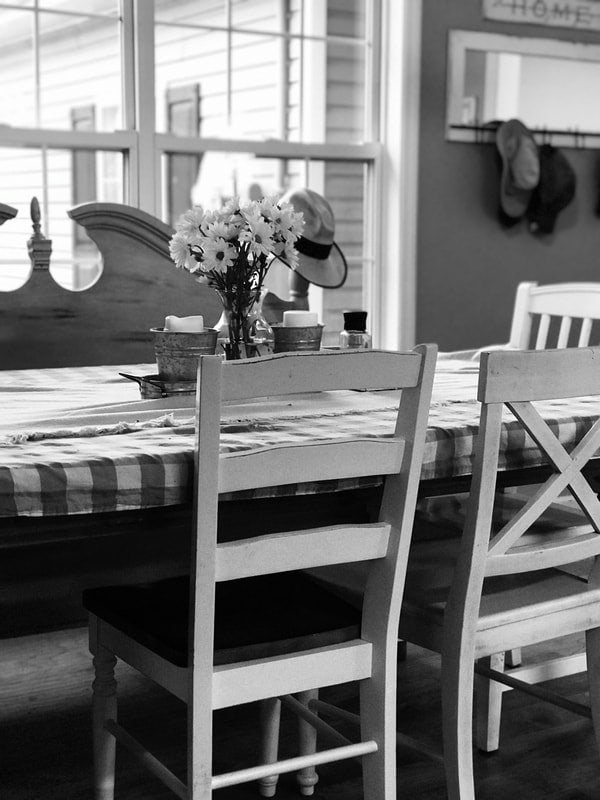 Elegant dining table with flowers and hats, cozy home interior.